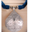 Detail of ethnic chic tribal style teardrop pendant Nomad necklace hand made from from silver metal & sabra silk in petrol blue