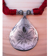 Detail of ethnic chic tribal style teardrop pendant Nomad necklace hand made from from silver metal & sabra silk in bordeaux