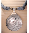 Detail of ethnic chic tribal style teardrop pendant Nomad necklace hand made from from silver metal & sabra silk in grey