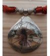 Dettaglio della collana Nomad etnica chic a goccia, collana fatta a mano in metallo argentato e seta sabra in arancione bruciato