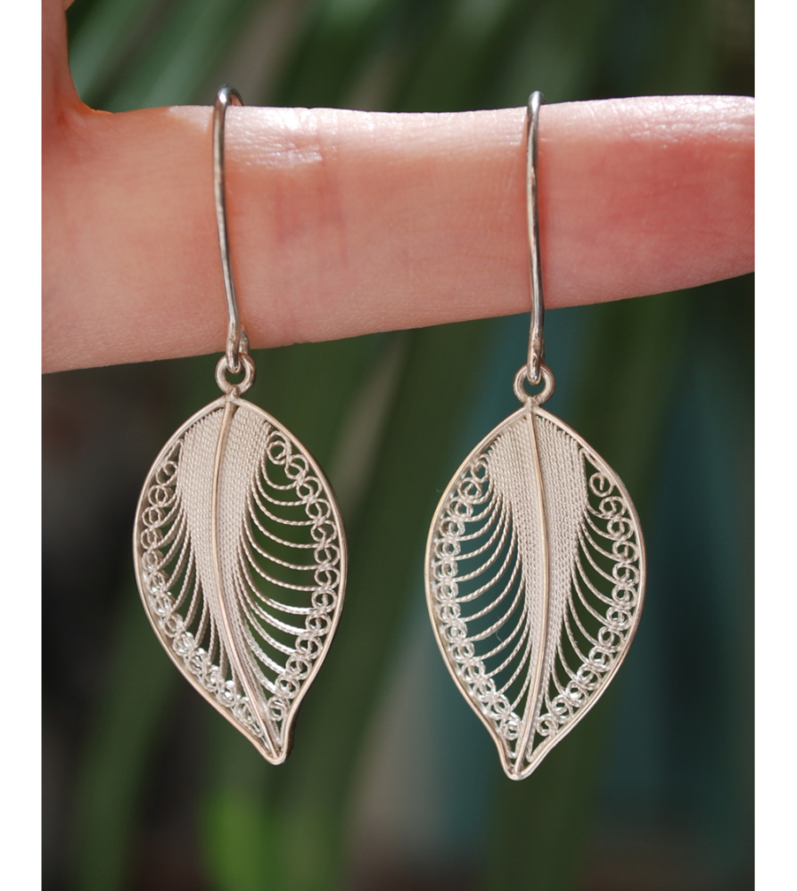 Beautifully delicate "Forever Leaves" filigree earrings handmade in 925 silver shown to scale hanging from a woman´s finger