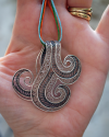 Artisan made Filigree "Wave" pendant necklace made in 925 oxidised and natural silver shown to size cupped in a woman´s hand