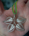Stunning artisan made "Forever Leaves" filigree silver pendant necklace shown to size in a woman´s hand