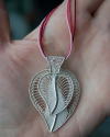 Filigree double "Leaf Heart" pendant necklace handmade in 925 silver shown to size in a female hand