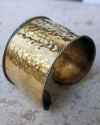 Side view of a slip on and off adjustable wide hammered copper cuff bracelet for her shown to size on a female wrist