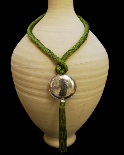 Artisan made ethnic chic art déco pendant necklace made from sabra silk in anise green and a hammered silver sphere with tassel