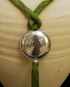 Detail of art déco pendant necklace  in anise green and a hammered silver sphere with hanging tassel