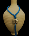Artisan made ethnic chic art déco pendant necklace made from sabra silk in turquoise and a hammered silver sphere with tassel
