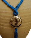Detalle de colgante arte déco con esfera plateada con felquillo con cadena de seda de sabra en turquesa de estilo étnico chic