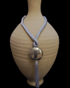 Hand made ethnic chic art déco pendant necklace made from sabra silk in light grey and a hammered silver sphere with tassel