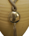 Detail of art déco pendant necklace in taupe and a hammered silver sphere with hanging tassel on a white backdrop
