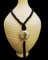 Hand made ethnic chic art déco pendant necklace made from sabra silk in black and a hammered silver sphere with tassel