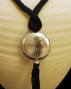 Detalle de colgante arte déco con esfera plateada con felquillo con cadena de seda de sabra en negro de estilo étnico