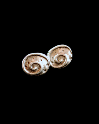 Vista frontale degli orecchini "Fossile" di forma ovale di Andaluchic in zama placcata argento ossidato sul sfondo nero