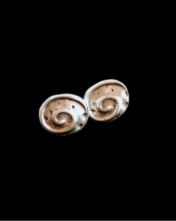 Front view of Andaluchic´s oval shaped "Fossil" Stud earrings made from oxidised silver plated zamak on a black backdrop