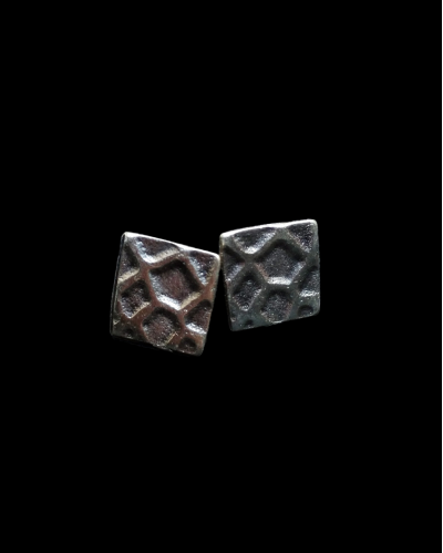Vue de face de clous d'oreille de motif "Carrés Géométriques" en zamak plaqué argent oxydé chez Andaluchic sur un fond noir