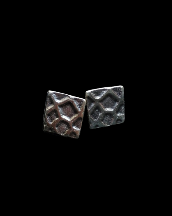 Vorderansicht der "Geometric"-Ohrringe von Andaluchic aus oxidiertem, versilbertem Zamak auf einem schwarzen Hintergrund