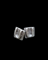 Front view of Andaluchic´s "U" motif stud earrings turned on it´s side made in oxidised silver plated zamak on a black backdrop