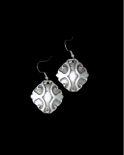 Front view of Andaluchic´s "Armour" drop earrings made of oxidised silver plated zamak displayed on a black backdrop