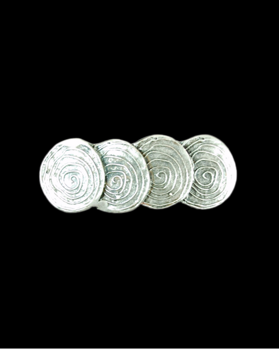 Vista frontale del fermacapelli "Quattro cerchi" in zama placcata argento anticato su sfondo nero