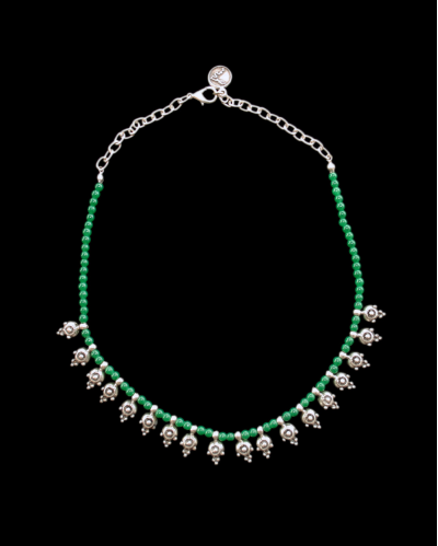 View of Andaluchic´s delicate "Crete" Necklace in antiqued silver plated zamak strung with green beads on a black backdrop