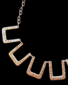 Detalle de cerca del collar retro "Troya" de Andaluchic, hecho de zamak plateado envejecido con líneas fuertes y femeninas