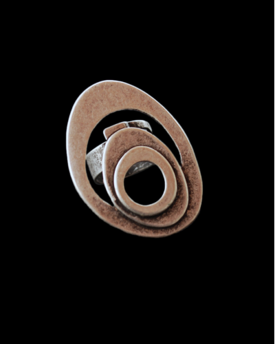 Vista frontale dell'anello "Vortice" regolabile da cocktail oversize in un design retrò etnico in zamak placcato argentato