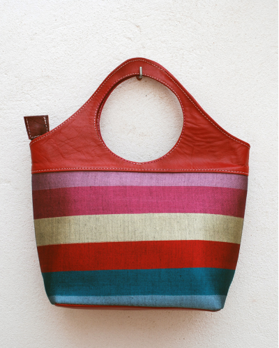 Red leather tote bag in striped fabric in pink, cream, red, turquoise and blue