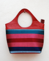 Red leather tote bag in striped fabric in pink, cream, red, turquoise and blue