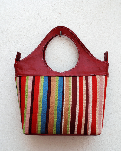 Red handbag in goatskin leather with vertical multicolored striped fabric
