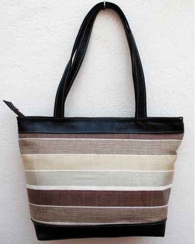 Large black leather shoulder bag with white, cream and brown striped fabric