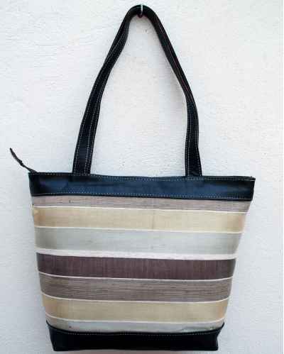 Large brown leather shoulder bag with striped fabric in white, cream and beige