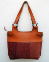 Front view of Andaluchic´s "Anillas" shoulder bag up-cycled in hand-woven cotton in reds & terracota combined with tan leather