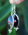 Pendants d'oreilles ovales faites main en argent avec des pierres semi-précieuses d'onyx noir avec un petit corail rouge central