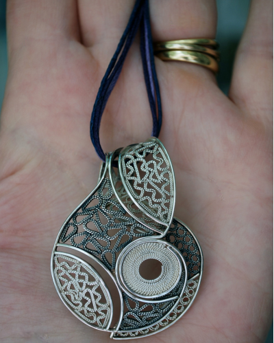 Artisan made filigree "Lucía" pendant necklace handmade in 925 oxidiised and natural silver shown to size in a woman´s hand