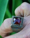 Square shaped chunky Byzantine style ring inset with a deep red diamond cut zircon in 925 silver with a golden patterned overlay