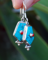 Oblong point drop earrings made in sterling silver inset with semi-precious stones of turquoise with small central red coral
