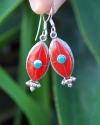Long Oval drop earrings hand made in silver inset with semi-precious stones of red coral with a small central turquoise