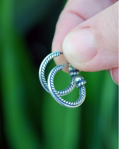 Filigrana etnica piccoli orecchini a cerchio fatti a mano in argento ossidato 925 mostrato a misura tenuto tra 2 dita