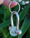 Handmade chunky silvered copper keyring with a clear glass bead a perfect gift for him or for her shown suspended from a finger