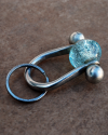 Porte-clés faite main de cuivre argenté avec pèrle transparen, un cadeau parfait pour lui ou pour elle sur un carreau terracota