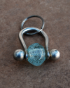 Handmade chunky silvered copper keyring with a clear glass bead, perfect gift for him or for her shown flat on a terracotta tile